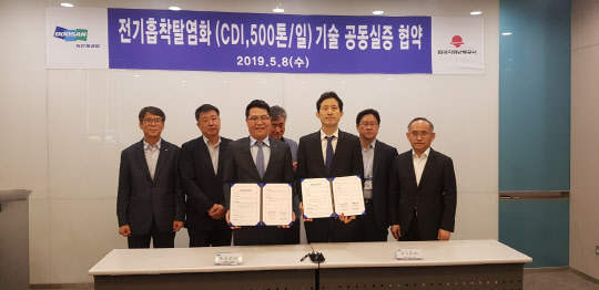 한국지역난방공사 성기준 미래개발원장(앞줄 오른쪽) 등이 8일 두산중공업에서 '전기흡착탈염화 기술 공동실증 협약'을 체결한 뒤 기념촬영을 하고 있다. <지역난방공사 제공>